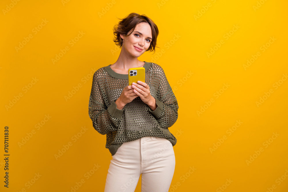 Poster Photo of lovely cute girl wear trendy outfit hold modern device apple iphone isolated on yellow color background