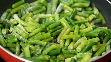 Green beans are being cooked in a pan, close up. Selective focus