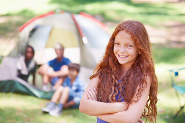 Child, portrait and fun at summer camp in outdoors, girl and relaxing on vacation or holiday. Happy female person, smiling and face or confident in park, childhood and adventure or joyful in nature