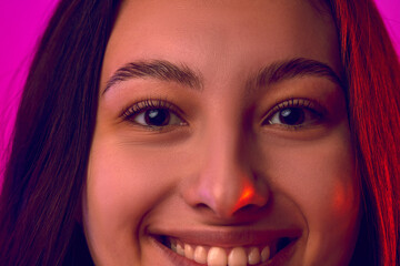 Extremely close up cropped portrait of face of young attractive woman smiling looking to camera...