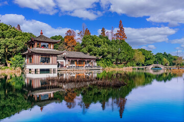 Fototapeta na wymiar Traditional East Asian Architecture and Autumn Scenery Reflected in Calm Waters, Serene Park Scene