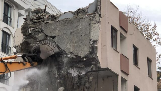 4K Construction Building - Demolition digger destroying an old building - Demolition of apartment block - Medium shot of house being demolished - Building demolition with scoop - Disintegration