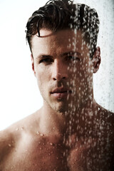 Serious portrait of man in shower to relax, cleaning hair and body for morning wellness, hygiene and routine. Grooming, skincare and face of male model with muscle in water splash, self care and calm