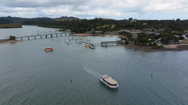 Aerial: Ferry boat in the harbour coastline alongside Waitangi, Northland, New Zealand. 6 January 2024