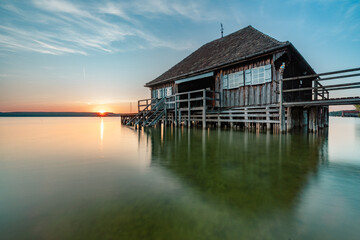 Fototapeta premium Haus am See bei Sonnenuntergang