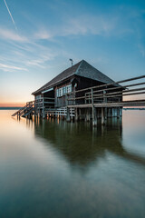 Fototapeta premium Haus am See bei Sonnenuntergang