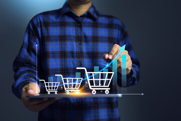 The growth of online shopping concept with a man holding tablet and shopping cart increase line...