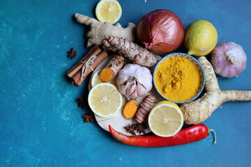 Fototapeta na wymiar Immune system booster ingredients top view photo. Spices and herbs on a blue background with space for text. Healthy eating concept. 