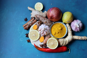 Fototapeta na wymiar Boosting immune system concept. Herbal remedy ingredients on a table. Root vegetables, herbs and spices. Anti inflammatory drink recipe. 