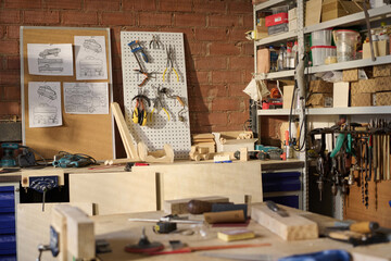 Background image of carpenters workshop lit by sunlight with tools and wooden models on shelves