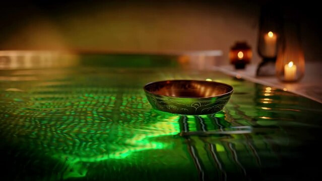 Tibetan bowl on the surface of the pool. Water relaxation and deep meditation. Loop Animation.