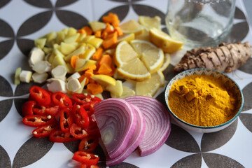 Fire cider chopped ingredients on grey tiled background. Top view photo of turmeric, ginger,...