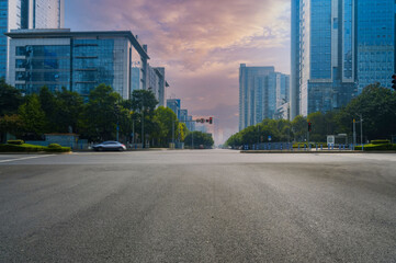 Dawn or Dusk in Urban Landscape with Empty Lanes, Red Traffic Lights, and Modern City Buildings