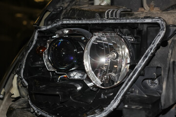 The car mechanic installs the lens in the headlight housing. The concept of a car service. Installation of BI-LED lenses in the headlight. BI-LED lens. Restoration of optics.