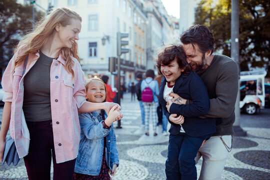 Joyful family laughing together on a city walk