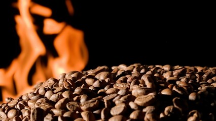 Coffee beans on a black studio background with burning tongues of flame. The process of roasting...
