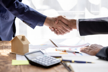 Real estate agent shakes hands with customer after finished contract after about home insurance and...