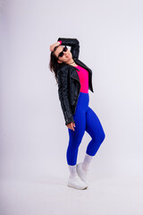 Woman with curvy figure in fashionable sportswear on grey and yellow background.