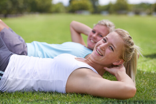Happy woman, portrait and friends in sit ups for outdoor exercise, workout or fitness together on green grass. Young active female person or people smile for training or health and wellness on field