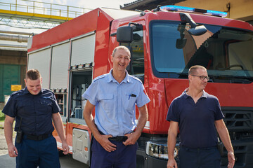 A skilled and dedicated professional firefighting team proudly poses in front of their state of the...