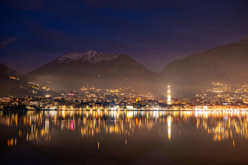 Fototapeta na wymiar The city of Lecco, with its lakeside promenade and its buildings, photographed in the evening in winter.