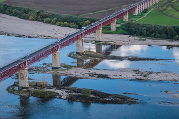Obraz premium Metallic red D. Luís I bridge over the Tagus river and reflected in it, Santarém PORTUGAL