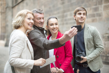 Tourists taking selfie on old street of European city