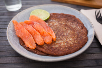 Salted salmon fillet with buckwheat pancakes and lime