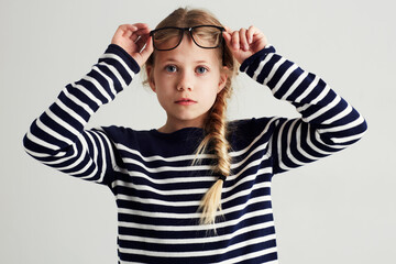 Fashion, portrait and girl kid in a studio with casual, cool and stylish jersey outfit and glasses....