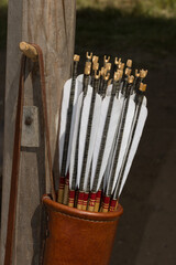 Leather bow quiver filled with arrows with graven woodnock and traditional natural fletching as...