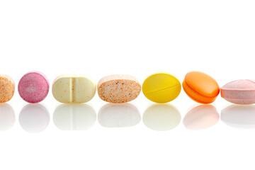 Obraz premium Colorful pills isolated on white background. Focus on foreground, soft bokeh.