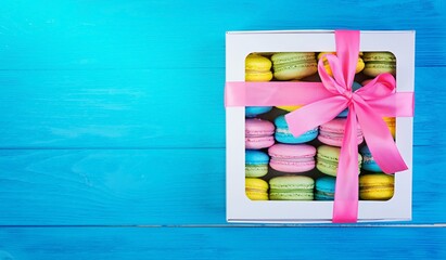 Delicious colorful macaron cakes on wooden background