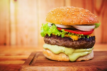 Delicious handmade burger on wooden background. Close view