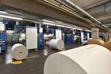 paper rolls and offset printing machines in a large print shop for production of newspapers &...