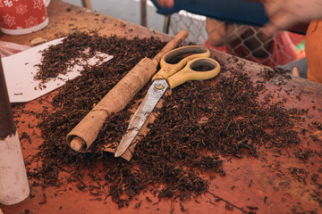 Tools and tobacco leaves for the production of handmade cigarettes in a market in Iquitos Peru