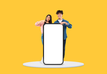 Cheerful young duo pointing at blank mobile screen - obrazy, fototapety, plakaty