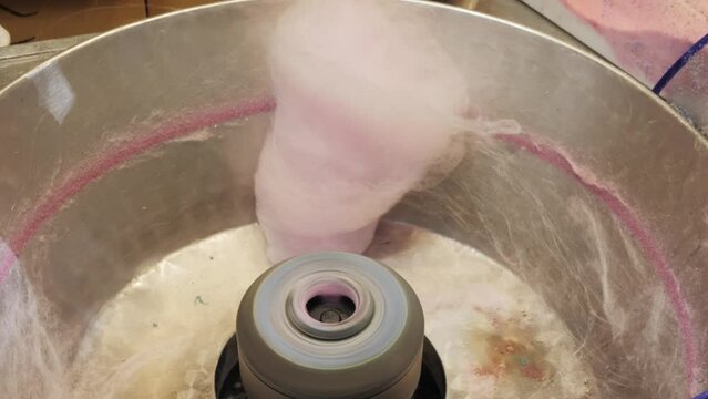 Making cotton sugar candy on street close-up. Candy floss macro. Food market. Treats for kids