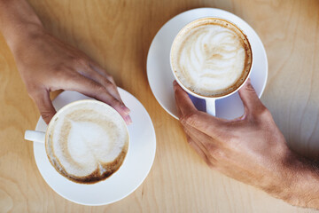 Top view, hands or couple in cafe with a coffee to relax with care, morning espresso or support. Closeup, date or people with tea, cappuccino or romance with love, peace or cup of tea in restaurant - obrazy, fototapety, plakaty