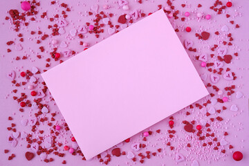 Blank pink mockup card with hearts for Valentine's Day on pink background. Flat lay, top view. Romantic love letter for Valentine's Day.