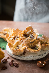 Phyllo pastry  cups with brie, jam, nuts sprinkled with powder sugar . Delicious filo pastry dessert