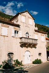 Ancient stone Bronze palace with attic and white wooden shutters. Perast, Montenegro