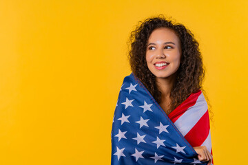 Happy woman with national USA flag on yellow. American patriot 4th of July, copy