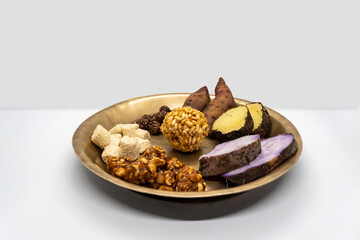 Maghe Sankranti Makar Festival Celebration Food Plate of Muri Ladoo, Sesame Ladoo, Yam, Sweet Potato, Jaggery, Peanuts Ladoo Ghee in India and Nepal