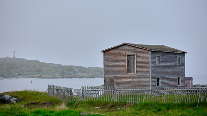 Old abandoned weathered old barn in fog and mist on Fogo Island in Newfoundland-Labrador