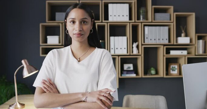 Serious, crossed arms and face of woman in office with creative career for planning at designing agency. Professional, confident and portrait of female designer standing by desk in modern workplace.
