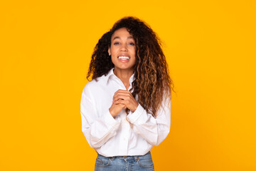 Smiling Black Woman Holding Hands Together Begging Over Yellow Background