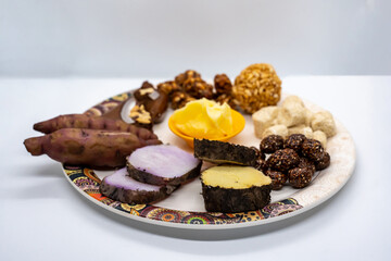 Maghe Sankranti Makar Festival Celebration Food Plate of Muri Ladoo, Sesame Ladoo, Yam, Sweet Potato, Jaggery, Peanuts Ladoo Ghee in India and Nepal