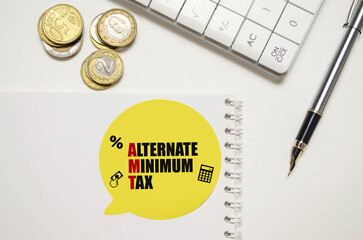 ALTERNATE MINIMUM TAX on yellow sticker on pen with coin