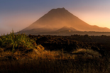 The Pico do Fogo volcano and the lava field at the foggy beautiful sunset at Fogo island, Cape Verde. - obrazy, fototapety, plakaty