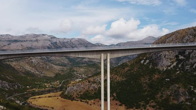 Aerial drone view of new highway reinforced concrete bridge over the Moraca river canyon in Montenegro, Europe. Modern expensive motorway road bridge in picturesque mountain valley.